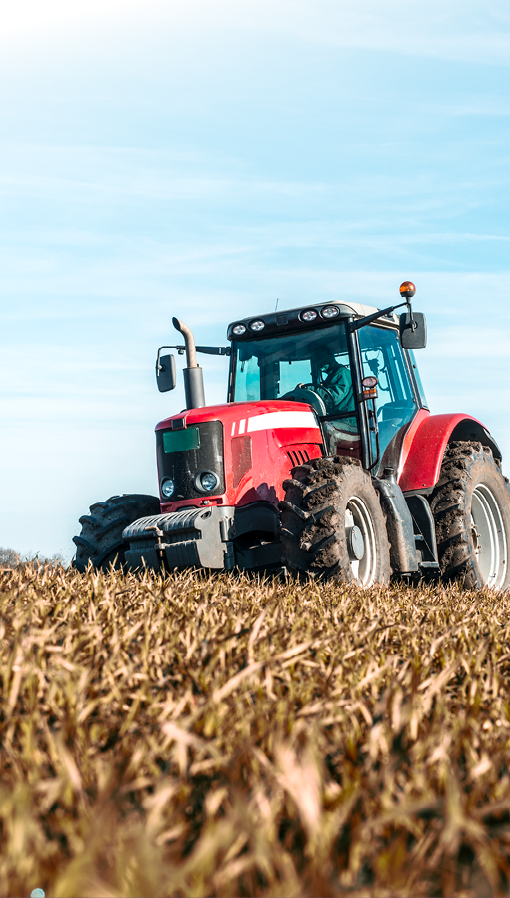 Tractor agricultural machine cultivating field.