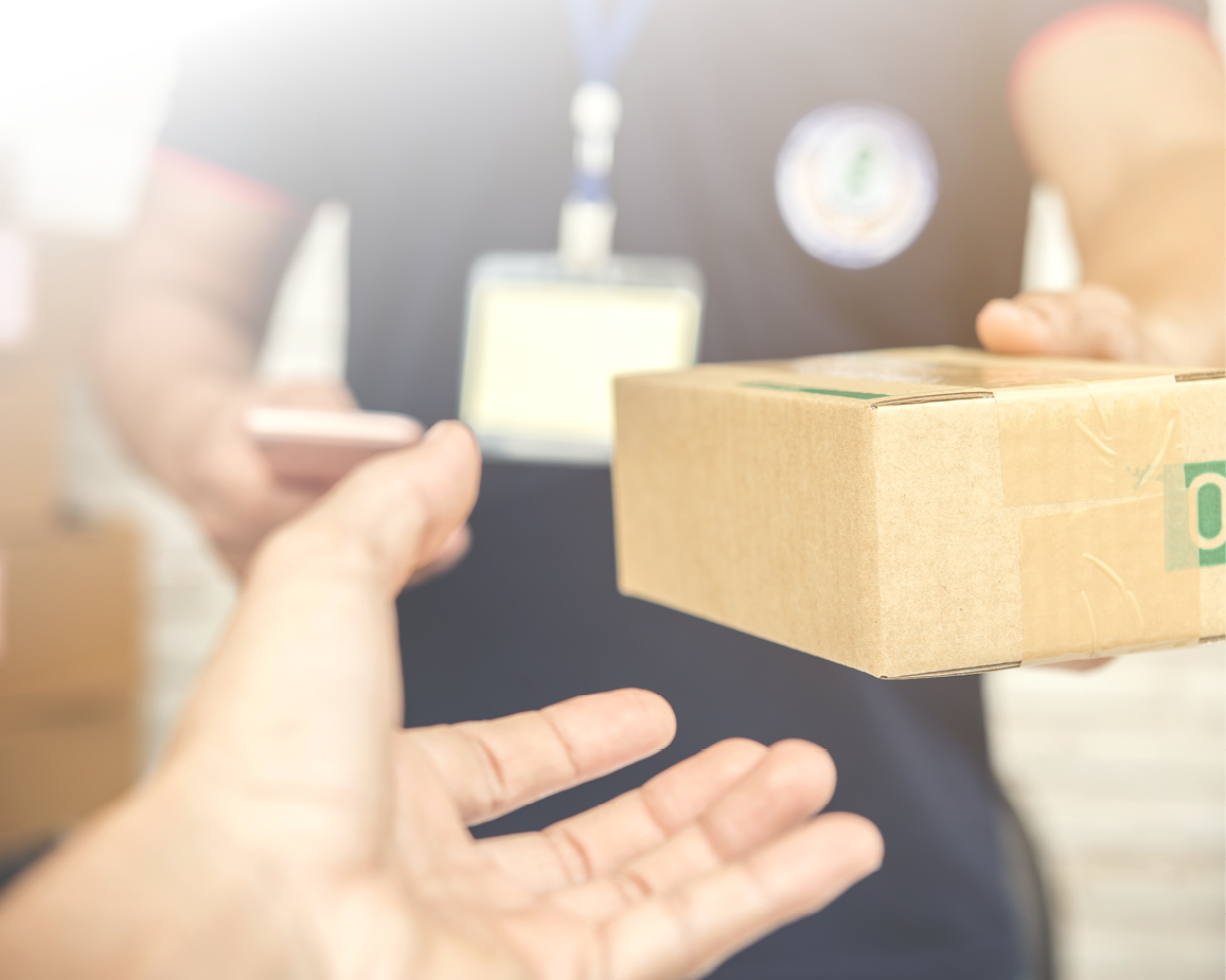 delivery man smiling and holding a cardboard box