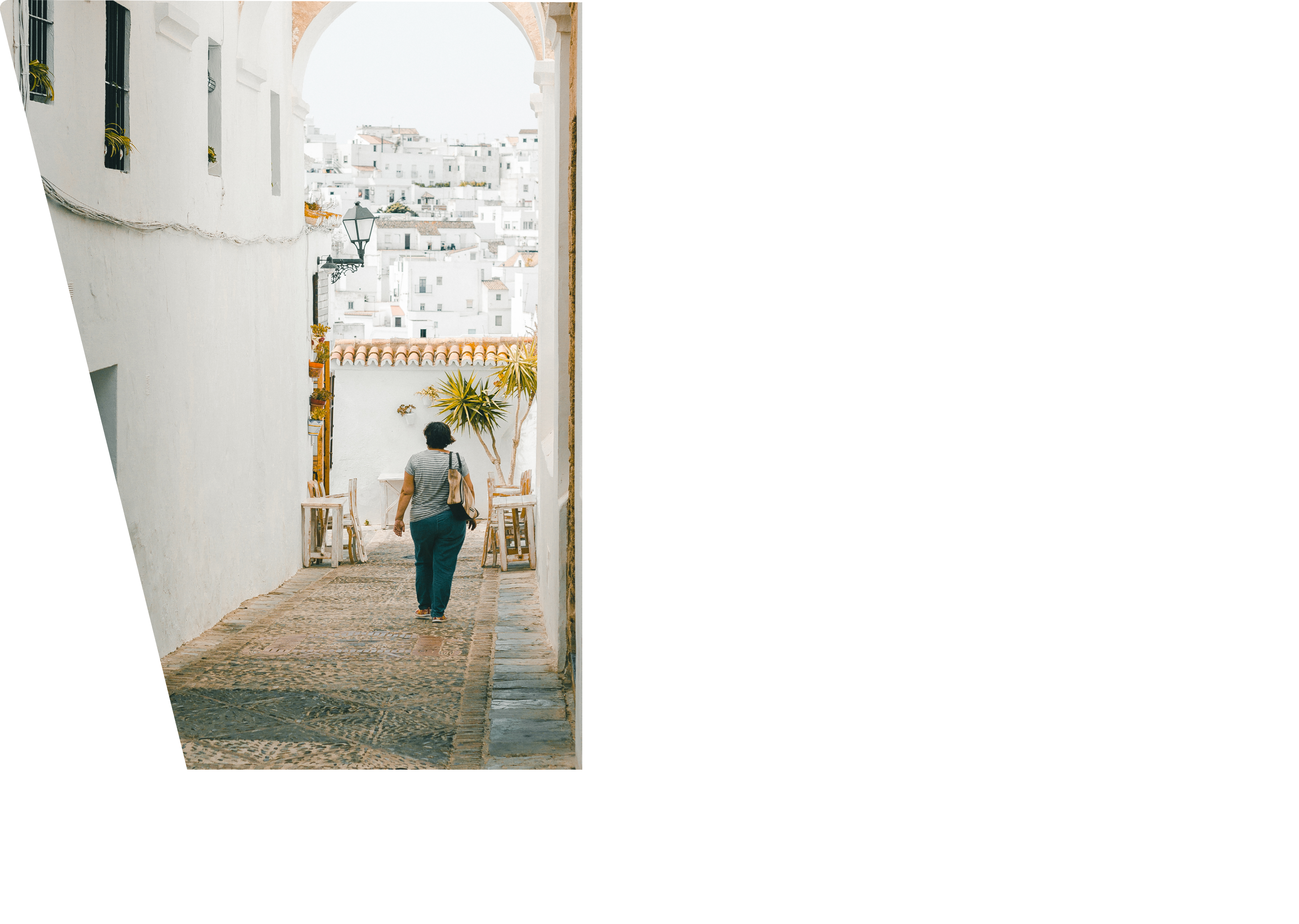 A vertical shot of a female walking in the narrow streets of Cadiz
