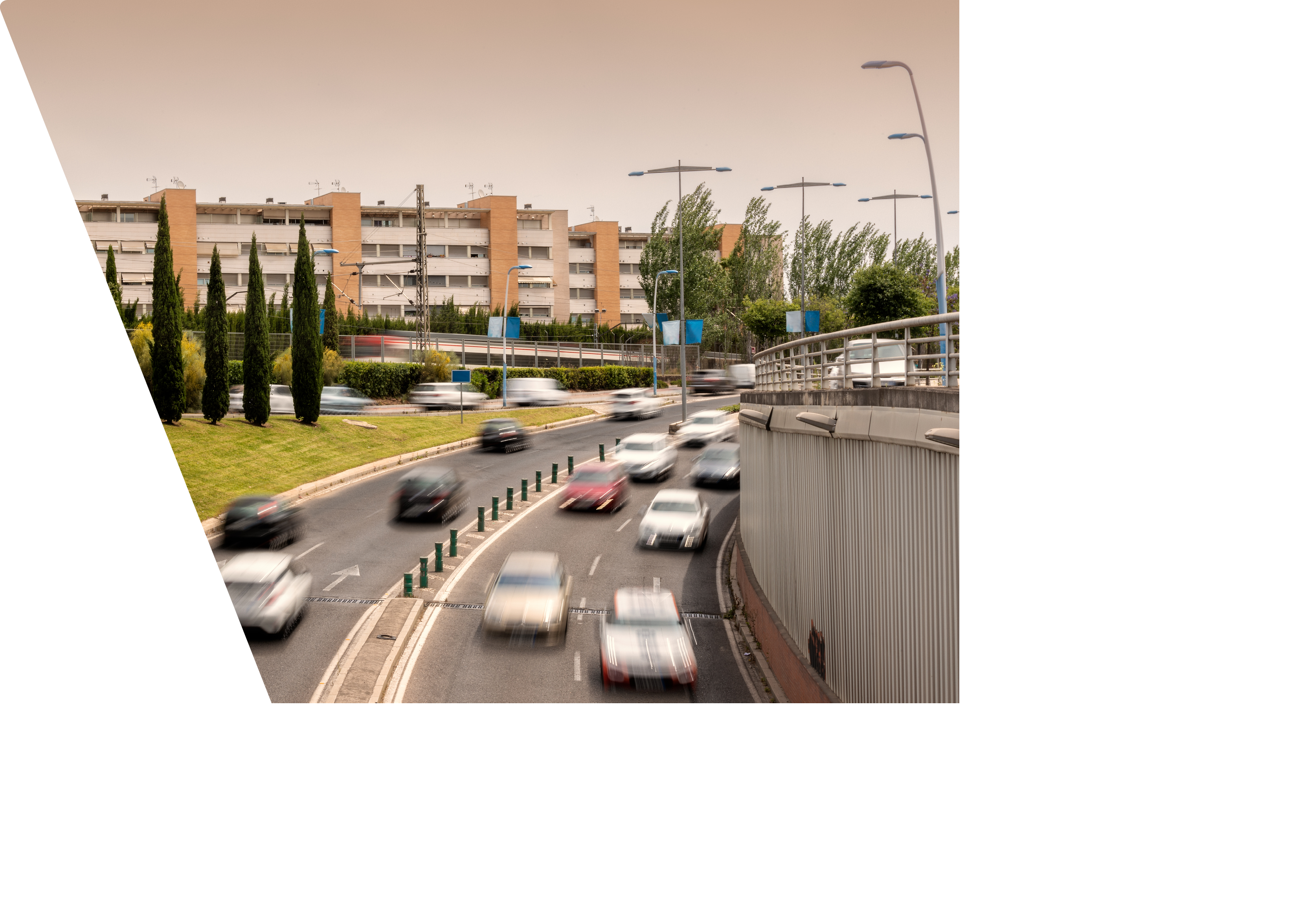 Many blurred cars in a road curve from above.