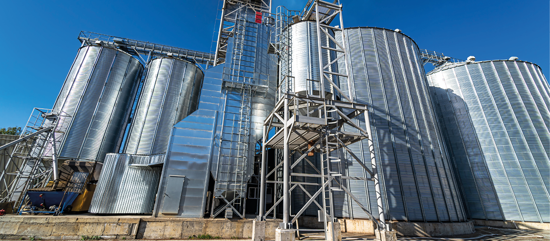 Metal grain elevator in agricultural zone. Harvested grain storage.