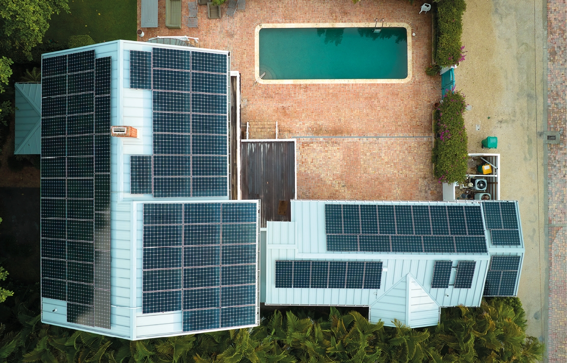 Expensive american residential house with rooftop covered with solar photovoltaic panels for producing of clean ecological electrical energy in suburban rural area. Concept of autonomous home.