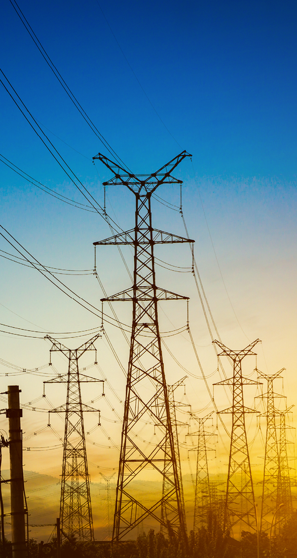 Sun setting behind the silhouette of electricity pylons