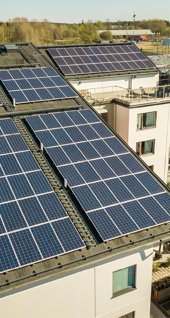 Aerial view of solar photovoltaic panels on a roof top of residential building block for producing clean electric energy. Autonomous housing concept.