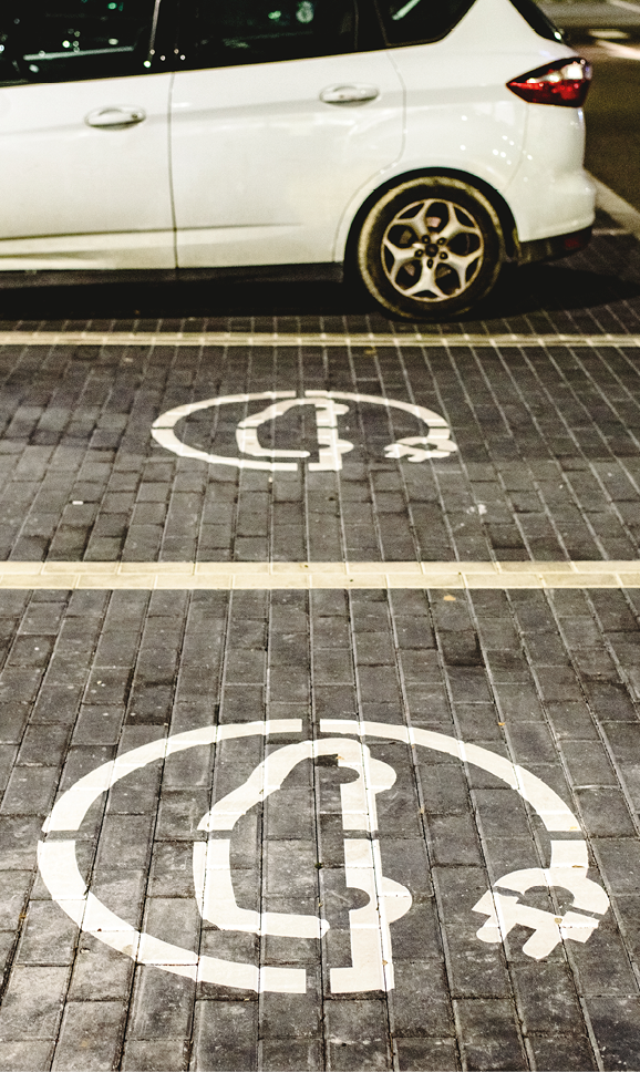 Roadsign of free electric car charging station in a European supermarket parking lot.