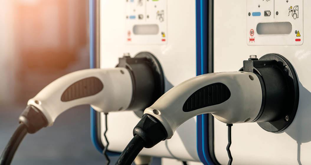 Electric car charging station. Plug for vehicle with electric motor. Coin-operated charging station. Clean energy power. Commercial charging station. Charging point. Infrastructure policy. 