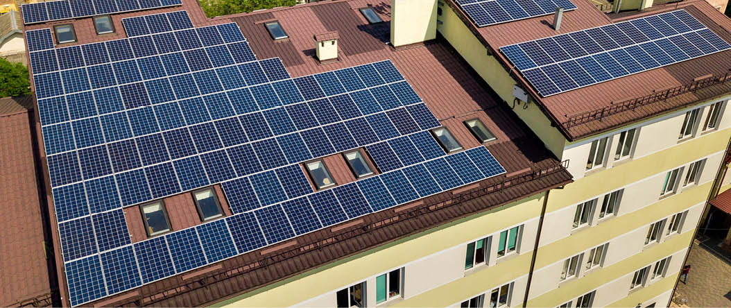 Aerial view of many solar panels mounted of industrial building roof.