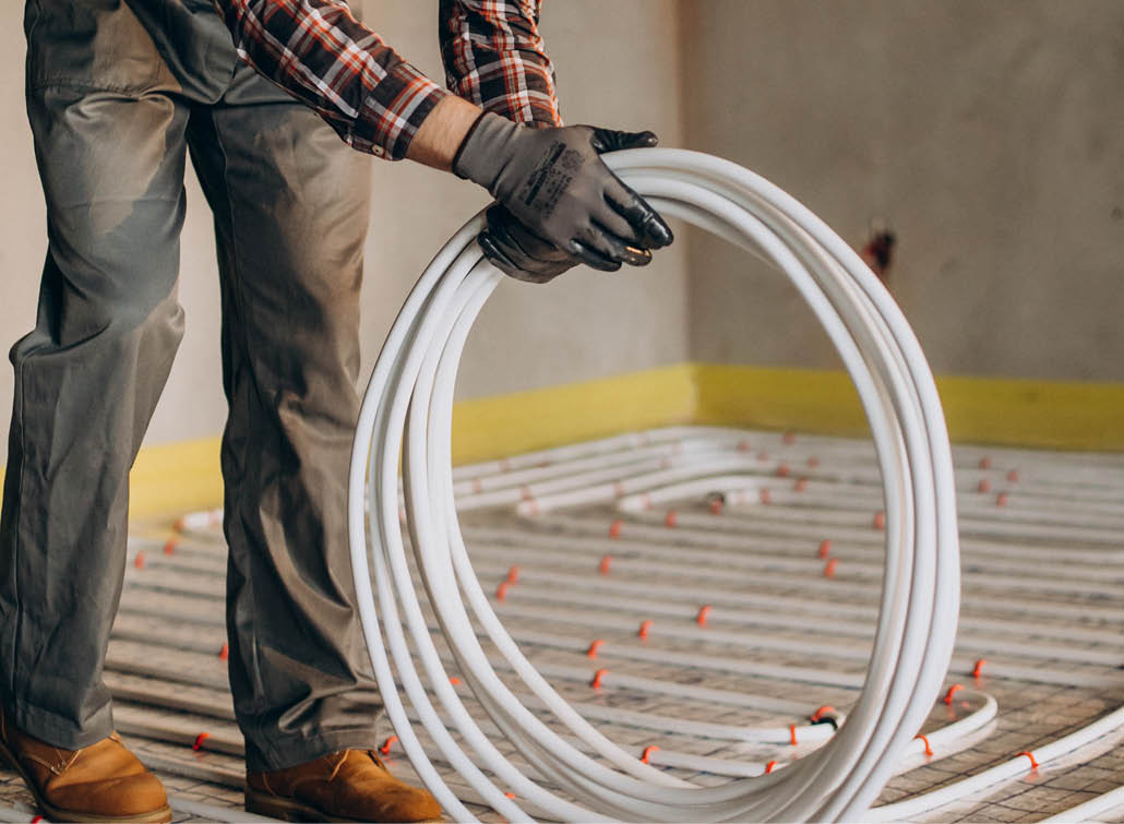 Service man instelling house heating system under the floor